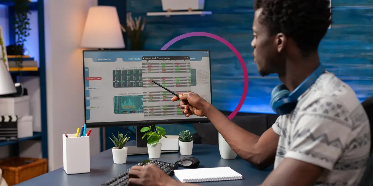 O COBIT é um framework de gerenciamento de TI. Homem apontando com uma caneta para o monitor do computador.