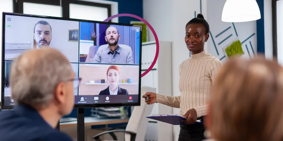 A gestão de equipes remotas é fundamental para o futuro do trabalho. - Mulher negra fazendo apresentação em sala de reunião durante uma videoconferência.