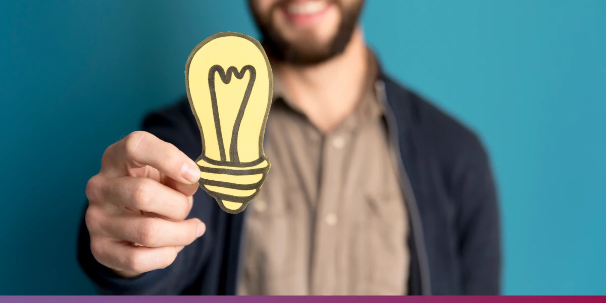 Conheça a metodologia Lean Startup. - Detalhe de mão masculina segurando um desenho de uma lâmpada.